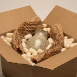 Colet e-commerce pregătit pentru expediere, protejând o vază ceramică cu materiale ecologice