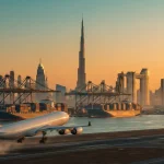 Panorama logistică Dubai: transport aerian și maritim cu Burj Khalifa în fundal la apus, simbolizând comerțul global