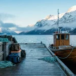 Peisaj din fiordurile Norvegiei cu echipament de pescuit și tuburi de lansete pregătite pentru transport pe ponton