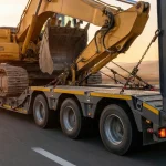 Trailer Lowbed cu gardă la sol redusă transportând un excavator agabaritic
